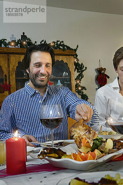 Vater und Sohn essen während der Weihnachtsfeier zu Abend