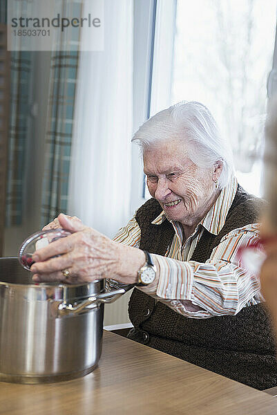 Ältere Frau kocht im Seniorenheim