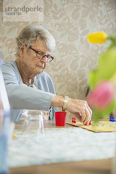 Ältere Frau spielt Brettspiel im Altersheim