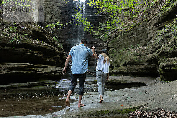 Ein Paar geht auf einen Wasserfall im Matthiessen State Park zu