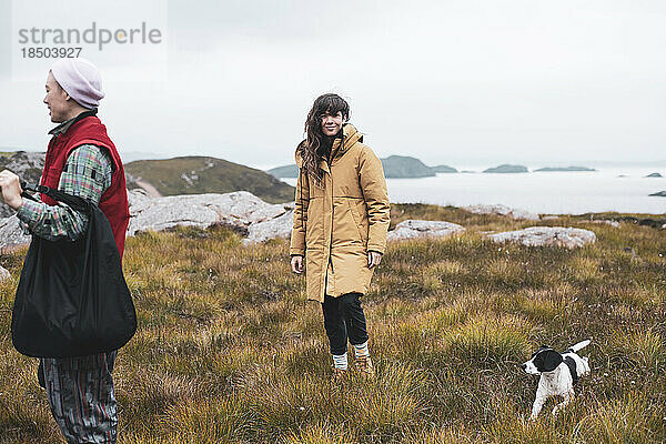Wanderer in Jacken lächeln oben auf der wunderschönen Aussicht im schottischen Hochland