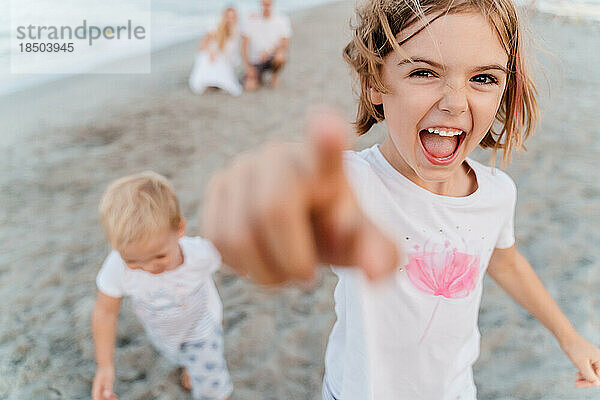 Fröhliche  glückliche Kinder  Bruder und Schwester  spielen am Strand