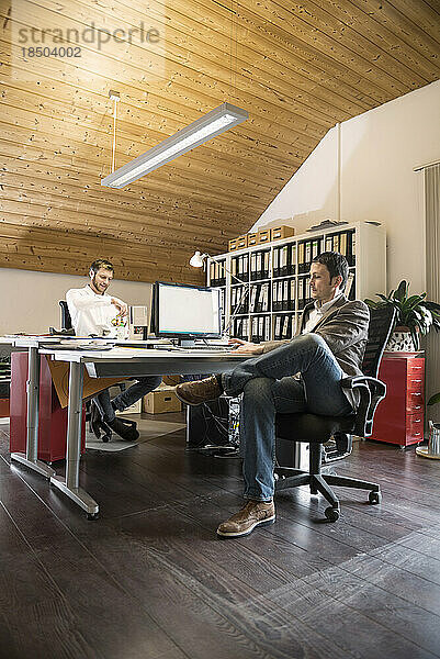 Zwei Geschäftsleute arbeiten am Computer in einem Büro  Bayern  Deutschland