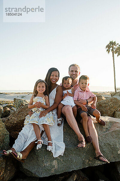 Fünfköpfige Familie posiert auf Felsen am Coronado Beach in San Diego