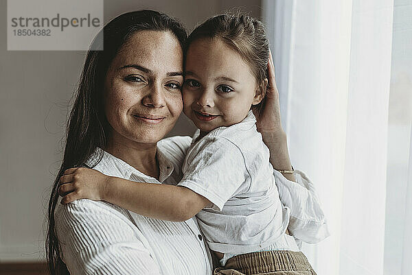 Nahaufnahme Porträt einer jungen Mutter und ihres kleinen Sohnes  die in die Kamera lächeln