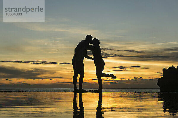 Silhouette eines küssenden Paares bei Sonnenuntergang am Strand  Nusa Lembongang  Bali  Indonesien