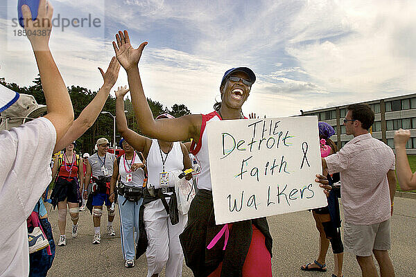 Members of the walker team The Detroit Faith Walkers give and get high-fives as they complete 60 miles in the Komen Breast Cance