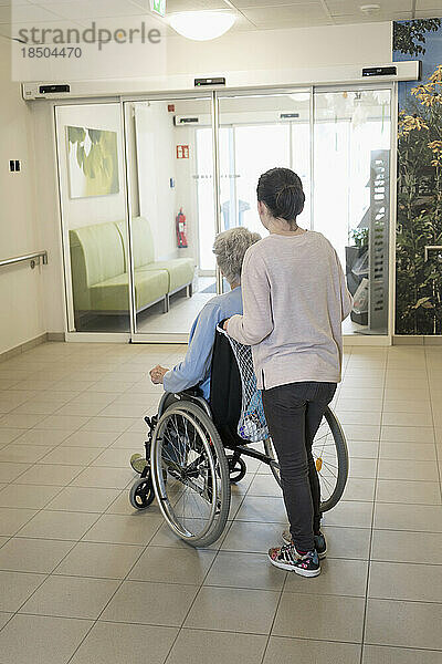 Ältere Frau im Rollstuhl mit Mädchen im Pflegeheim