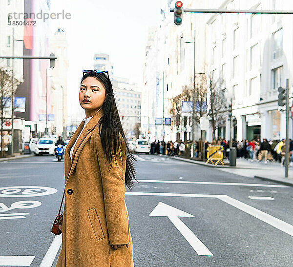 Asiatisches Mädchen überquert die Straße der Gran Via in Madrid