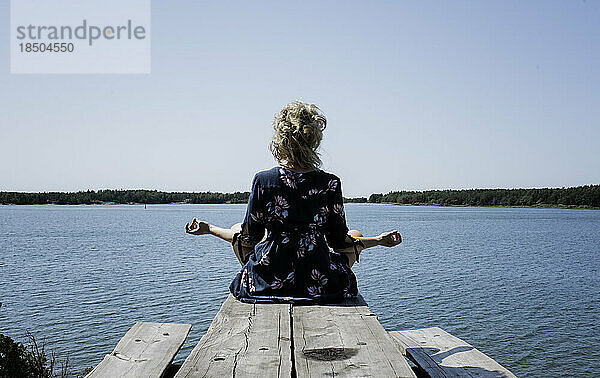 Eine Frau saß im Urlaub meditierend draußen und blickte auf das Meer