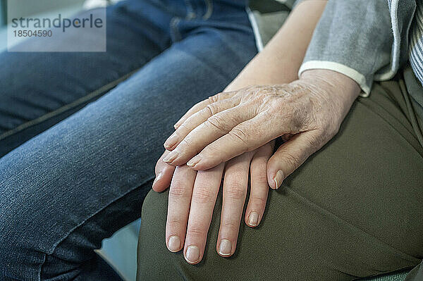 Ältere Frau hält die Hand eines Mädchens