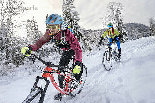 Mountainbiker in Sportbekleidung radeln im Schnee