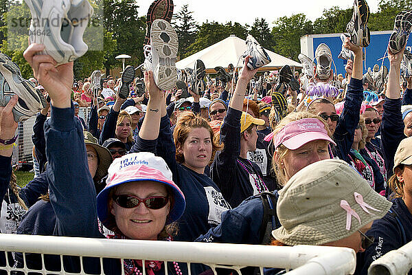 Walkers raise their shoes to honor breast cancer survivors at the end of the 60 mile Komen 3-Day walk for breast cancer in Detro