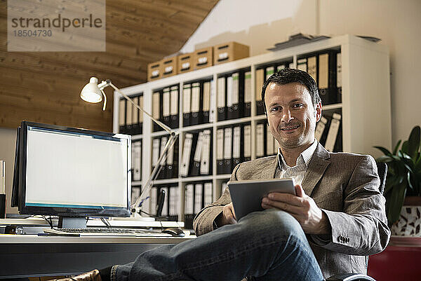 Porträt eines reifen Geschäftsmannes mit digitalem Tablet in einem Büro  Bayern  Deutschland