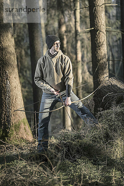 Mann schießt mit Pfeil und Bogen im Wald  Bayern  Deutschland