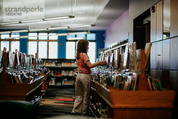Profil eines Tween-Mädchens  das sich Bibliotheksbücher ansieht
