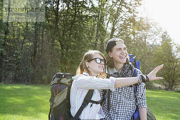 Junge Wanderin zeigt ihrer Freundin etwas in einem Wald  Bayern  Deutschland