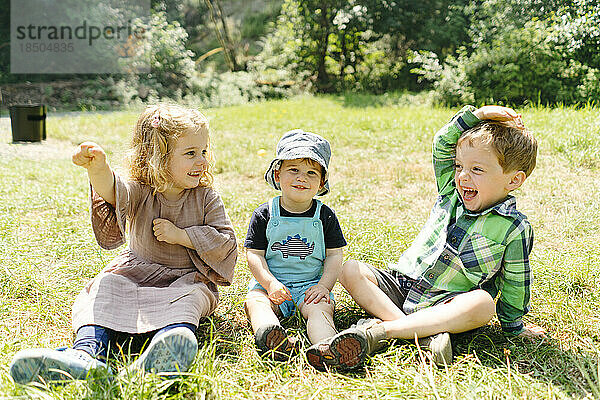 Geradeaus Porträt von drei Kindern  die zusammen spielen und lachen