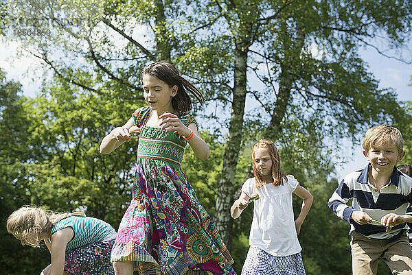 Gruppe von Kindern  die in einem Eier-und-Löffel-Rennen in einem Park in München  Bayern  Deutschland  gegeneinander antreten