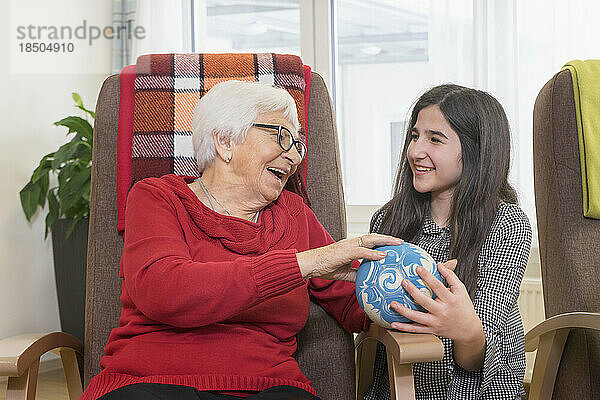 Mädchen spielt Bowling mit Seniorin im Pflegeheim