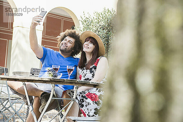 Junges Paar macht Selfie mit Handykamera im Restaurant im Freien