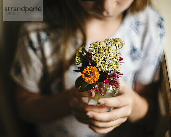 Kleines Mädchen macht in der Küche einen Blumenstrauß