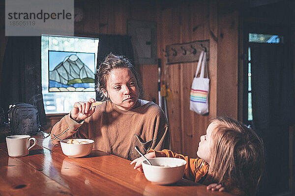 Mutter und Tochter frühstücken in einer Waldhütte