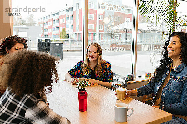 Vielfältige Freundesgruppe lacht im Café