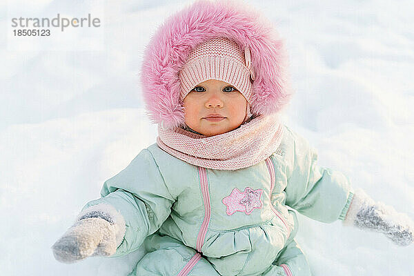 Nahaufnahme eines Winterporträts eines süßen  rötlichen Kleinkindes im Schnee