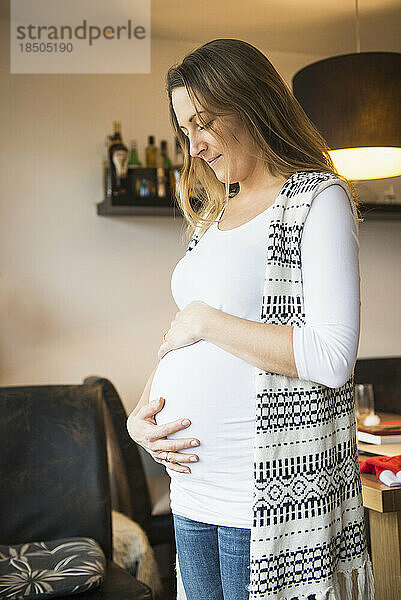 Schwangere Frau blickt auf ihren Bauch  München  Deutschland