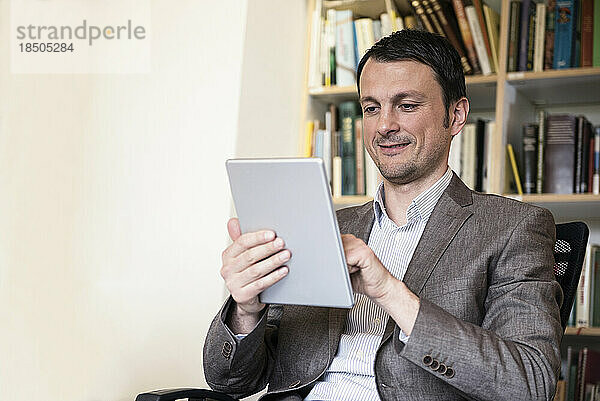 Reifer Geschäftsmann nutzt digitales Tablet in einem Büro  Bayern  Deutschland