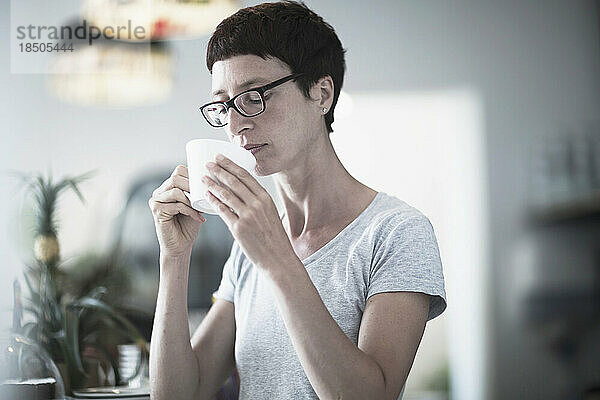 Reife Frau trinkt Kaffee im Büro  Freiburg im Breisgau  Baden-Württemberg  Deutschland