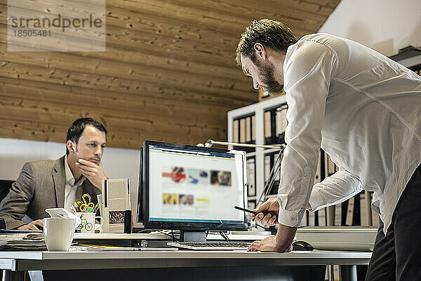 Zwei Geschäftsleute arbeiten am Computer in einem Büro  Bayern  Deutschland
