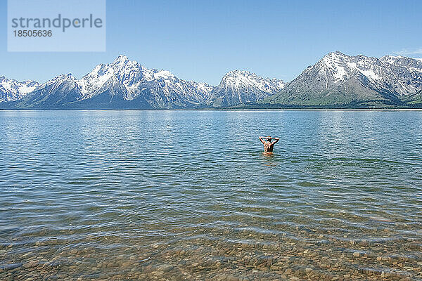 Teenager schwimmt allein im Alpensee