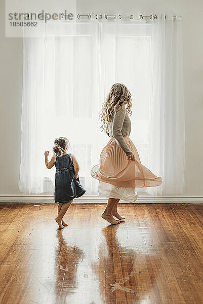 Mother and young daughter dancing in studio