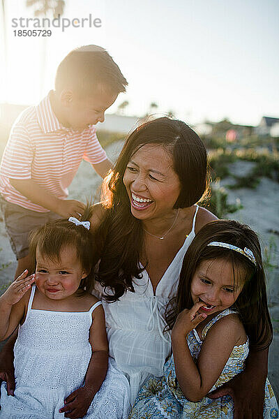 Lustige Nahaufnahme von Mutter und drei Kindern am Strand von San Diego bei Sonnenuntergang
