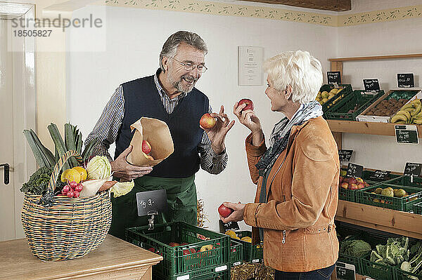 Reife Frau kauft Obst und Gemüse im Laden  Bayern  Deutschland
