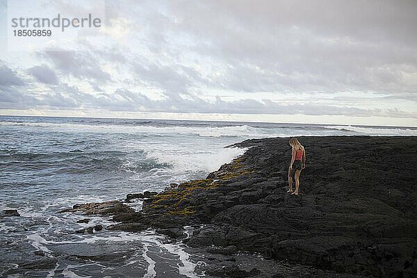 Ein Mädchen läuft auf Lavafelsen in der Nähe des Ozeans  Big Island  Hawaii.