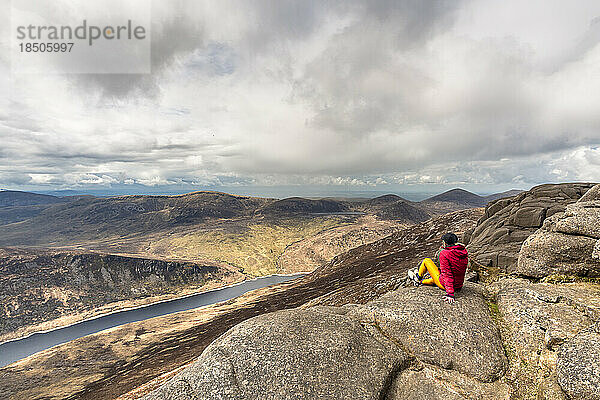 Frau sitzt auf dem Gipfel der Slieve Binnian Mountains