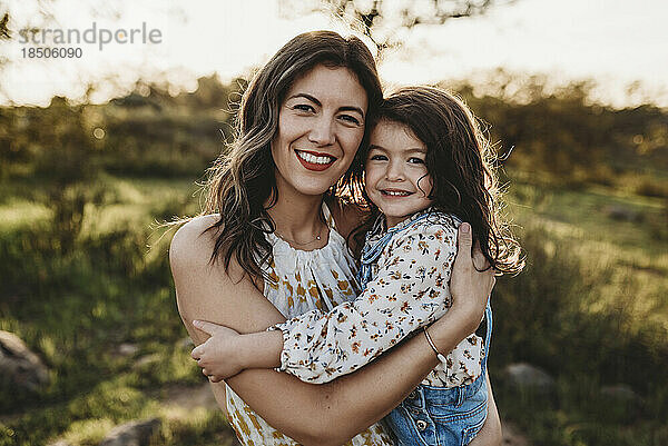 Porträt einer jungen Mutter und Tochter auf einem sonnigen Feld