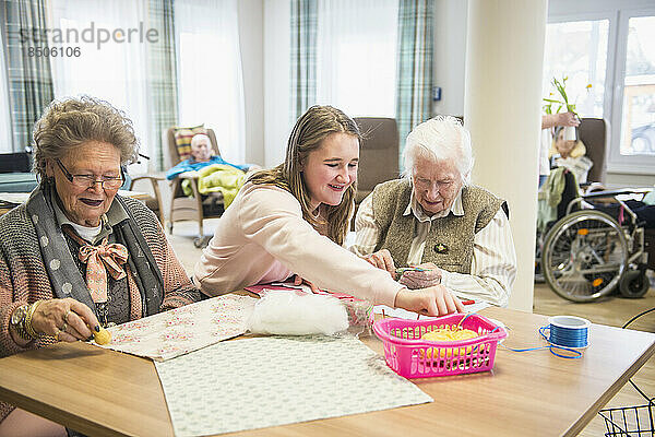 Ältere Frauen mit Mädchen machen handwerkliche Aktivitäten im Erholungsheim