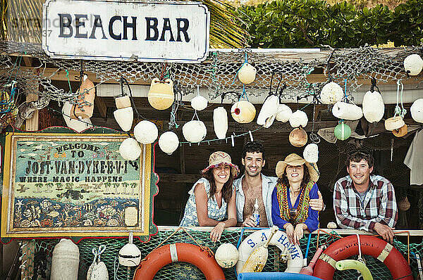 Vier junge Freunde in einer tropischen Strandbar.