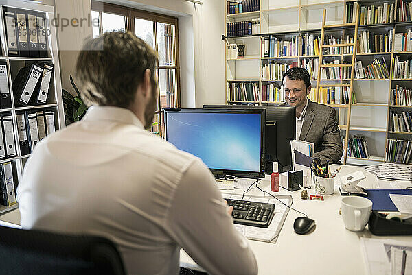 Zwei Geschäftsleute arbeiten am Computer in einem Büro  Bayern  Deutschland