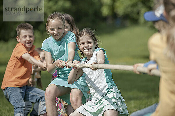 Gruppe Kinder spielen Tauziehen in einem Park  München  Bayern  Deutschland