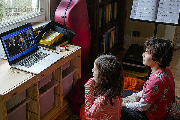 Zwei Kinder schauen sich zu Hause am Computer die Amtseinführung von Biden an