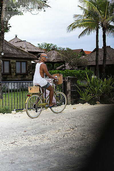 Ein Mann fährt mit dem Fahrrad zum Strand  Bali.