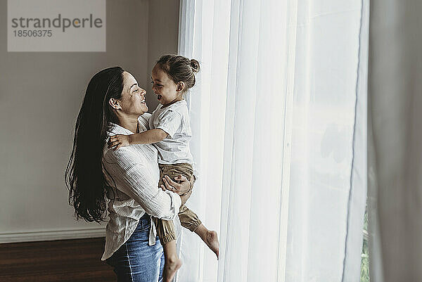 Side view of mother and toddler son playing in natural light studio