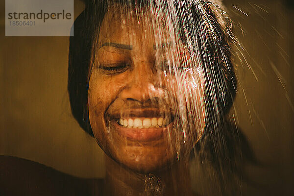 schwarze sinnliche Frau in einer Dusche unter Wasser
