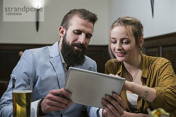 Paar nutzt digitales Tablet im Restaurant