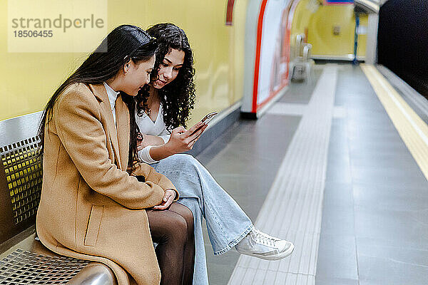 Stockfoto von zwei Mädchen  die das Handy in der U-Bahn benutzen